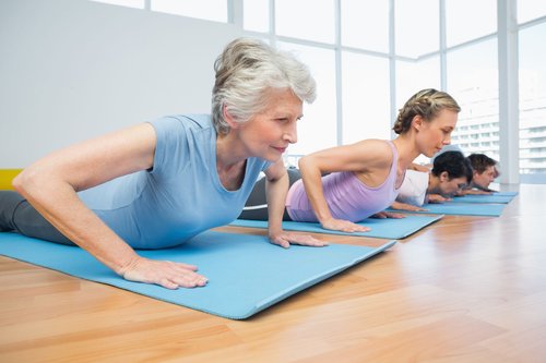 Personas realizando ejercicios de pilates terapéutico dirigidos por su fisioterapeuta