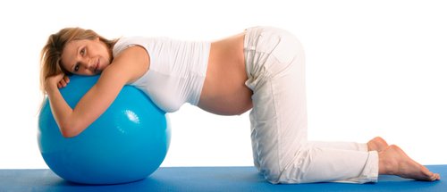 Mujer embarazada realizando ejercicios de pilates supervisados por su fisioterapeuta